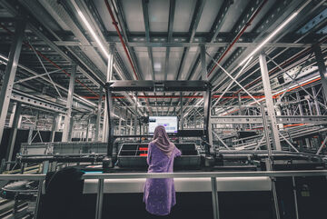 An employee looks at the screen at her workstation in the warehouse